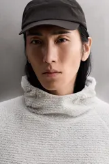 Sudadera regular fit de tejido polar con textura efecto pelo, color gris claro. Cuenta con cuello subido, capucha ajustada, manga larga ranglán, bolsillos laterales en la cadera y bajo asimétrico más largo en la espalda. Los acabados son con cinta elástica.