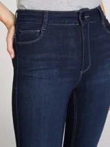 Pantalón de jean corte skinny, de tiro medio y color azul oscuro con costuras en contraste.