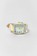 Reloj de pulsera con caja cuadrada de borde blanco y detalles dorados, esfera con números romanos y marcadores de hora con incrustaciones de cristales, y malla de cuero sintético color blanco.