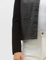 Chaqueta Sioni con frente de cuero sintético y mangas y espalda de tejido de punto. Presenta cuello a la base, cierre frontal con botones a presión y bolsillos delanteros.