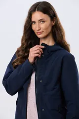 Campera liviana con capucha, de corte clásico, color beige, con bolsillos laterales con solapa y cierre frontal.