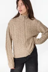 Campera de punto tejido color beige con diseño de ochos, cuello alto y cierre frontal completo.