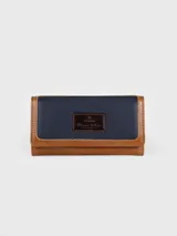 Billetera combinada de cuero en tonos marrón y camel, con solapa frontal de pelo vacuno estampado y detalle de placa con el logo de la marca.