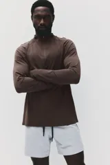 Remera deportiva de manga larga con cuello elevado y medio cierre, de color marrón, con diseño entallado Muscle Fit y detalles de paneles texturizados.