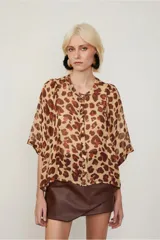 Camisa de manga corta con estampado animal print, cuello bote, abotonada en el frente y de fit amplio.