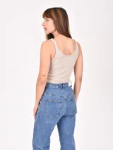 Musculosa de tejido acanalado color beige, con escote redondo y estampado frontal con la frase 'LESS IS MORE' en color negro.