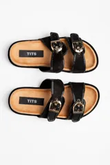 Sandalias negras con dos tiras horizontales con hebillas doradas ajustables.