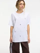 Camiseta blanca de algodón con cuello redondo y mangas cortas, decorada con brillantes plateados.