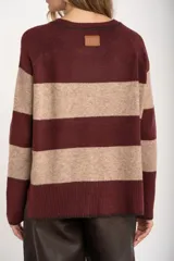 Sweater de punto con diseño de rayas horizontales anchas en color bordó y beige. Presenta cuello redondo con detalle de lurex, mangas largas y puños y ruedo acanalados.