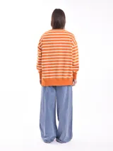 Buzo verde con rayas horizontales blancas, de corte holgado y cuello redondo.