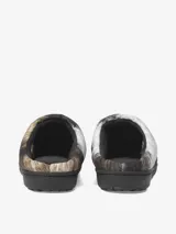 Pantuflas acolchadas de diseño slip-on, resultado de la colaboración entre Carhartt y Subu. Presentan un estampado animal print en tonos grises, blancos y marrones, con suela de goma negra, etiqueta cuadrada de Carhartt y bordado de la marca Subu en el lateral.