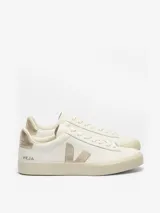 Championes Veja modelo Campo, de diseño minimalista en color blanco con detalles en dorado metalizado en el logo lateral y el talón. Presentan suela de caucho en tono crema y cierre mediante cordones.
