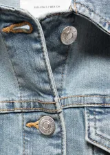 Chaqueta de denim celeste, con diseño corto, cuello de solapa, cierre frontal de botones metálicos, bolsillos frontales con solapa y bolsillos laterales ribeteados.