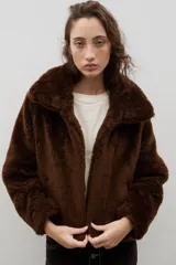 Campera corta de piel sintética en color crema, con cuello amplio tipo solapa y cierre frontal.