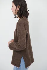 Buzo de tejido de punto color beige, con corte relajado, cuello redondo y mangas largas. Presenta detalles de terminaciones en color azul marino en los puños y en el ruedo inferior.