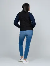 Chaleco acolchado Tommy Hilfiger de color negro, con cuello alto, cierre frontal de cremallera y dos bolsillos laterales de ojal.