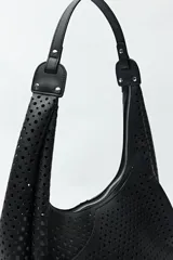 Cartera de hombro color beige con diseño calado y estructura semirrígida.