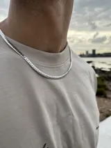 Cadena de eslabones tipo cubana o curb, de color plateado, con acabado brillante.