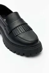 Mocasines negros de suela track chunky, con detalle de flecos y tira en el empeine.