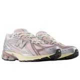 Championes New Balance modelo 1906, con diseño técnico en tonos rosa y detalles metalizados plateados. Presenta una estructura de malla transpirable, refuerzos sintéticos y entresuela con tecnología de amortiguación en color crema.