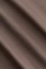 Remera de microfibra color marrón, con diseño entallado, mangas largas y escote redondo ribeteado.