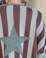 Buzo de tejido de punto con diseño de rayas verticales en tonos tostado y crema, destacando una gran estrella central en color verde oliva.