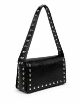 Bolso de mano tipo bandolera negro de cuerina, con solapa y tira decorada con tachas metálicas plateadas. Cuenta con asa corta para llevar al hombro y detalles de tachas en los laterales y bordes inferiores.