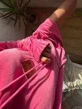 Buzo de plush oversize color fucsia, con capucha y cordones.