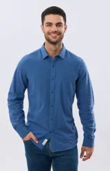Camisa de lino de manga larga en color beige, con cuello camisero, cierre frontal de botones y un bolsillo ojal en el pecho.