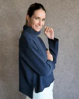 Sweater color crudo de cuello alto con mangas largas y corte holgado.