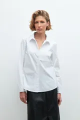 Camisa blanca de manga larga con cuello clásico y cierre frontal con botones.