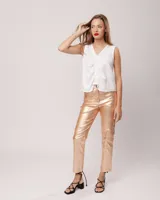 Pantalón negro estilo jeanero confeccionado en gabardina elastizada con terminación metalizada, pierna recta con largo por arriba del tobillo, cierre delantero y botón.