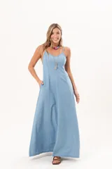Vestido largo de denim fino y liviano, color celeste, con breteles finos, escote delicado, silueta entallada en la parte superior, falda amplia con recortes verticales y bolsillos laterales.