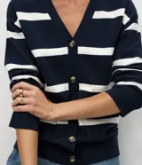 Cardigan de tricot color marrón con rayas horizontales negras, escote en V, cierre frontal con botones y dos bolsillos aplicados.