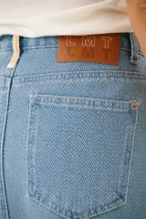 Falda midi de jean celeste con corte recto y cinturón negro con hebilla metálica.