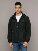 Campera ligera Calvin Klein de corte regular, confeccionada en tejido técnico resistente al viento y la llovizna. Presenta cierre frontal con cremallera, capucha ajustable con cordones, bolsillos laterales con cierre y puños elásticos.