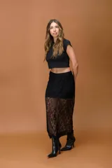 Falda larga de encaje negro con diseño de transparencias y forro corto integrado. Presenta una silueta recta y fluida con acabado delicado.