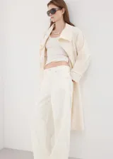 Jeans de tiro alto y diseño balloon en color blanco, con estilo vaquero, trabillas para cinturón, cinco bolsillos tradicionales y cierre frontal de botón y cremallera.