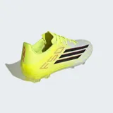 Championes de fútbol Adidas F50 League, diseñados para velocidad y precisión. Presentan una parte superior Fiberskin con textura 3D para un mejor control del balón, construcción Tunnel Tongue para un ajuste seguro y suela Sprintplate 360 con tacos planos y semicónicos para tracción en múltiples terrenos. Combinan un tono amarillo neón con detalles en blanco y las icónicas tres tiras de la marca en negro con bordes rojos.