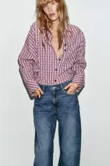 Jeans de tiro alto con diseño barrel, caracterizado por una silueta curvada y holgada en la zona de los muslos y rodillas, estrechándose hacia el tobillo. Cuenta con cinco bolsillos y cierre frontal con cremallera y botón.