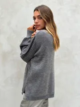 Sweater de punto color gris oscuro con hilos de lurex plateados, cuello redondo y mangas largas abullonadas con puños ajustados.