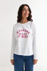 Remera de manga larga color beige con cuello redondo a la base. Presenta un estampado frontal con un dibujo de labios en color fucsia y la palabra 'BESITO' en color negro.