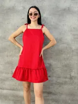 Vestido corto rojo de satén con breteles finos que se atan en los hombros y falda con volados.