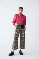Camisa fucsia de cupro con cuello alto y cartera cruzada en delantero con abotonado de snaps soft-touch. Tiene terminación redondeada con pequeños tajos en los laterales.