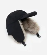 Gorra de estilo aviador con visera curva, confeccionada en poliéster negro. Presenta solapas laterales con forro de piel sintética para cubrir las orejas y ajuste trasero regulable.