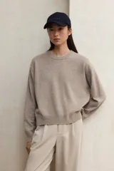 Suéter de punto básico, color beige melange, con cuello redondo y puños y ruedo acanalados.