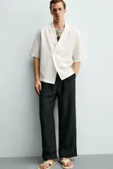 Camisa tipo kimono de corte relaxed fit, color celeste, confeccionada en tejido fluido de viscosa y lino. Presenta cuello con solapas de muesca, manga corta y cierre frontal cruzado con doble botonadura.