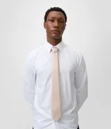 Corbata de corte regular confeccionada en tejido satinado, color beige con estampado geométrico de rombos.