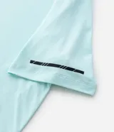 Remera deportiva de hombre con tecnología dry fit, cuello redondo y manga corta. Presenta un diseño liso en color beige con una pequeña etiqueta decorativa en el dobladillo.