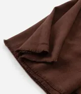 Bufanda femenina de punto liviano en color negro, con diseño básico y terminación deshilachada en los extremos.